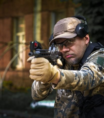 Combat training soldier of special forces. Man in military ammunition stand in guard. Military man hide in position with weapon in hands. Ranger during the military operation Combat training soldier of special forces. Man in military ammunition stand in guard. Military man hide in position with weapon in hands. Ranger during the military operation.